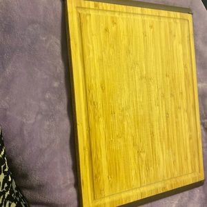 Wood large cutting board with brown edge that is rubber to keep from sliding.